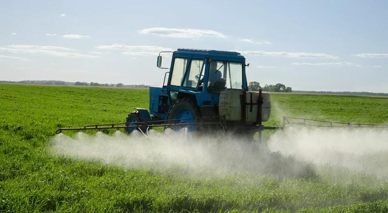 Niebieski traktor na&nbsp;polu